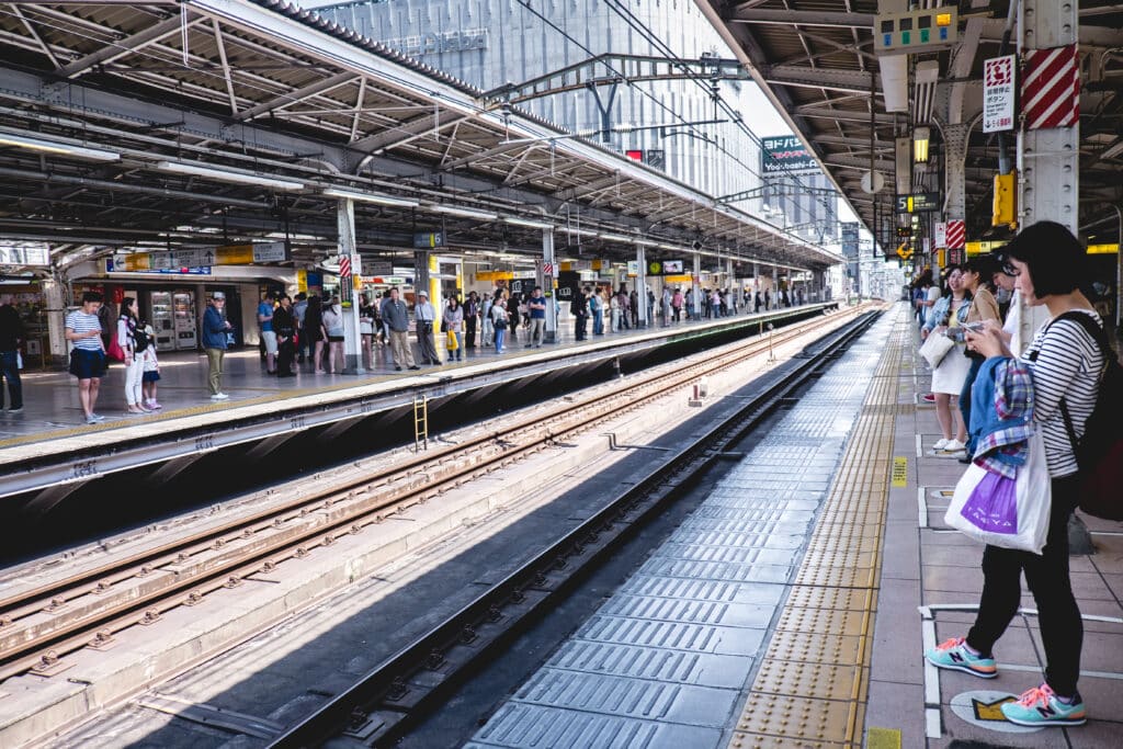Passengers waiting on a busy local train platform in Japan