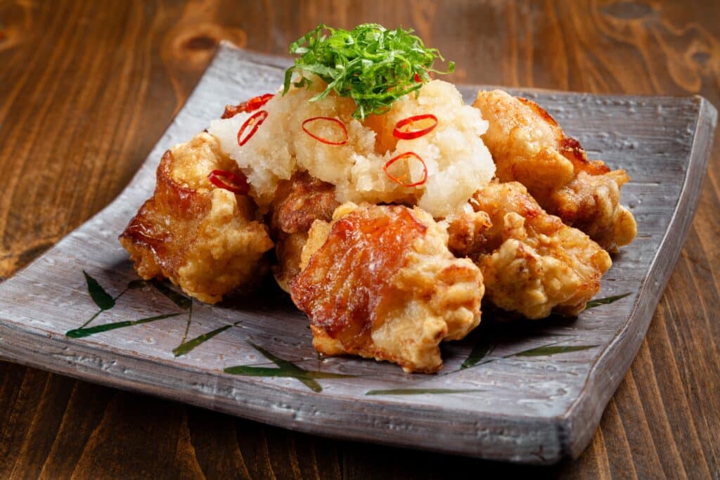 Karaage Japanese fried chicken served with grated daikon and herbs