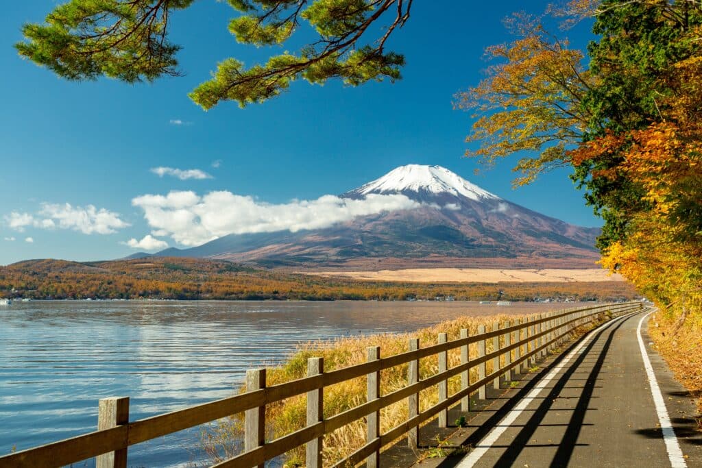 Mount Fuji seen from Lake Kawaguchiko with lakeside path and autumn foliage
