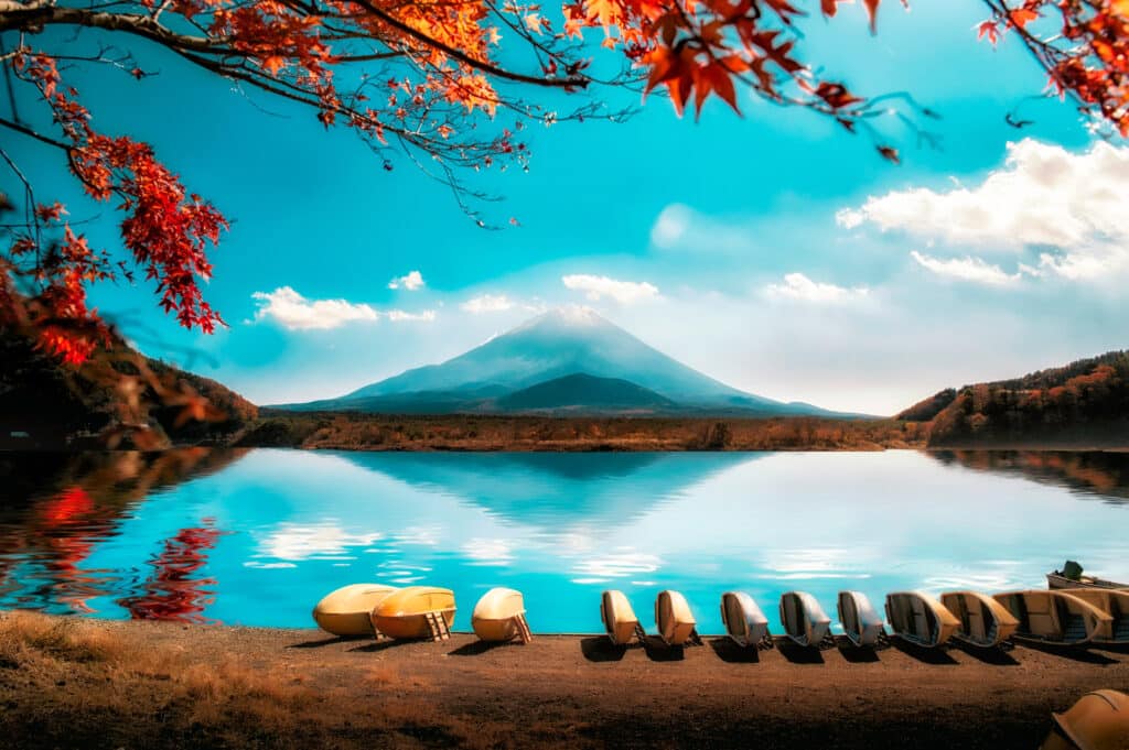 Mount Fuji viewed across a lake with boats in the foreground