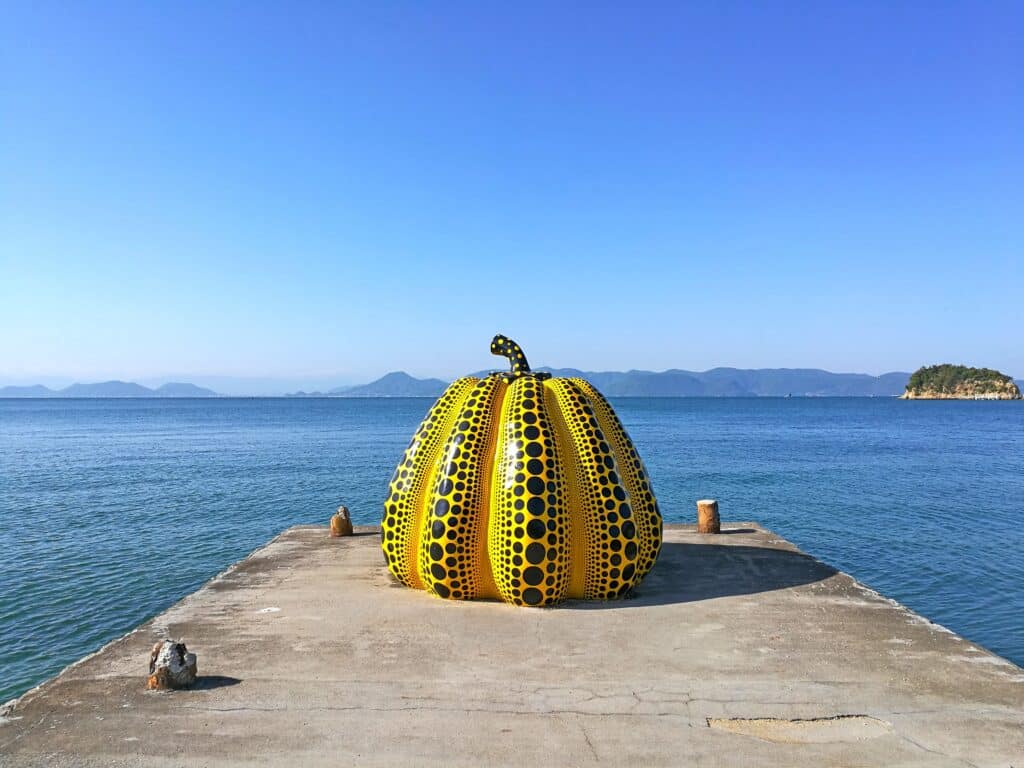 Yellow pumpkin sculpture on Naoshima island overlooking the sea