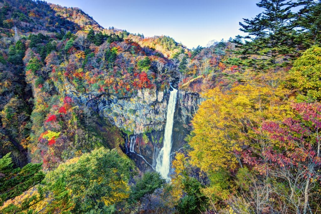 Waterfall in Nikko surrounded by colorful autumn foliage