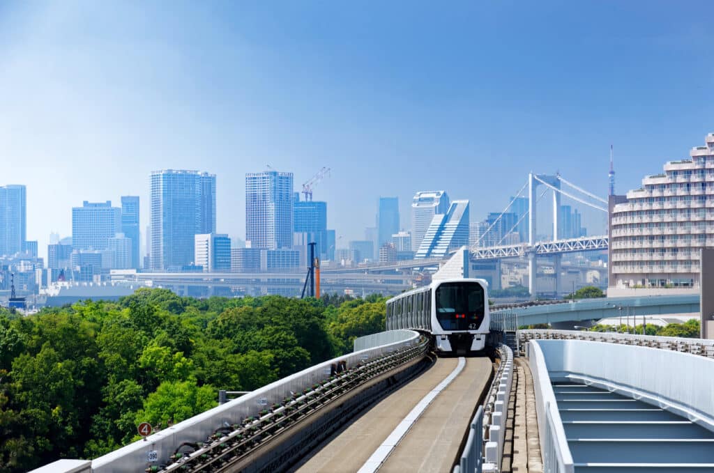 Yurikamome train in Odaiba Tokyo with skyline and Rainbow Bridge