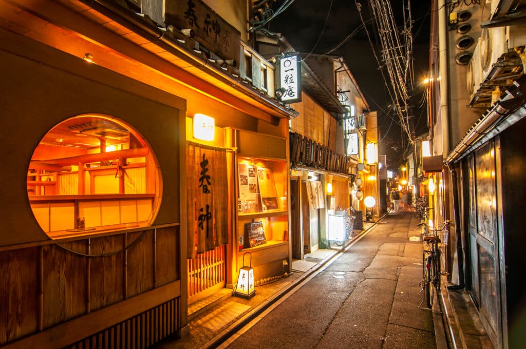 narrow Pontocho Alley in Kyoto at night with lantern-lit restaurants