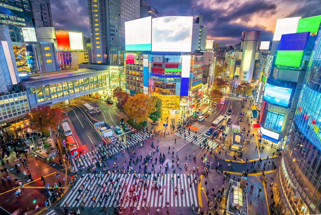 Neon-lit street in Shinjuku Tokyo at night with crowds