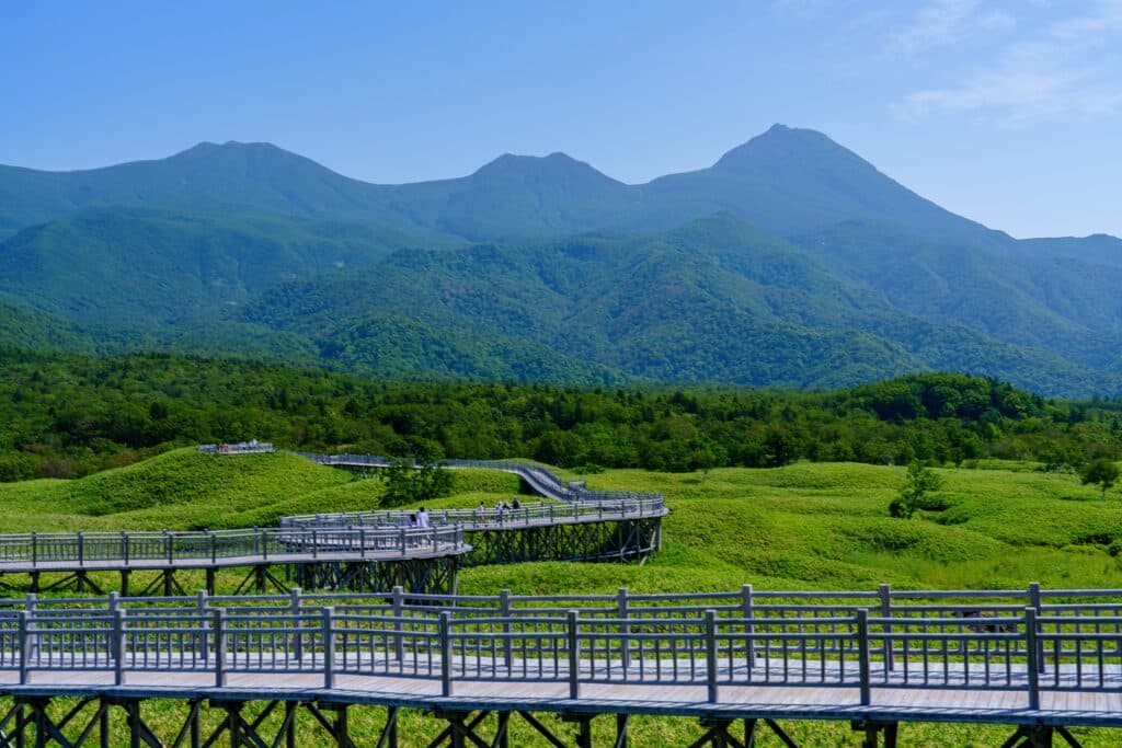 Wooden boardwalk through Shiretoko National Park with mountains in Hokkaido