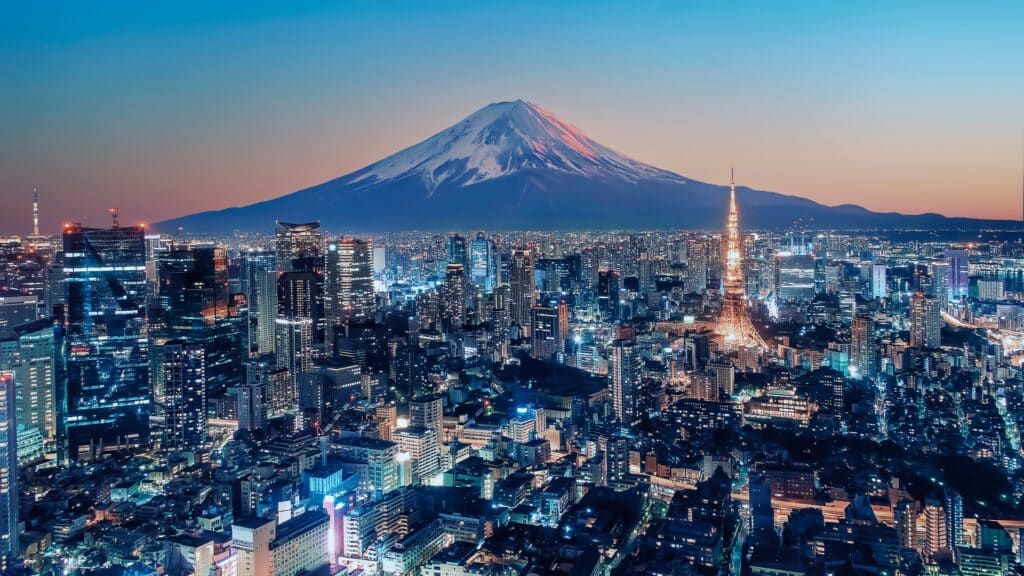 Tokyo skyline at dusk with Tokyo Tower lit up and Mount Fuji in the background