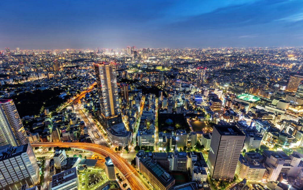 Panoramic Tokyo skyline at night with illuminated buildings and city lights