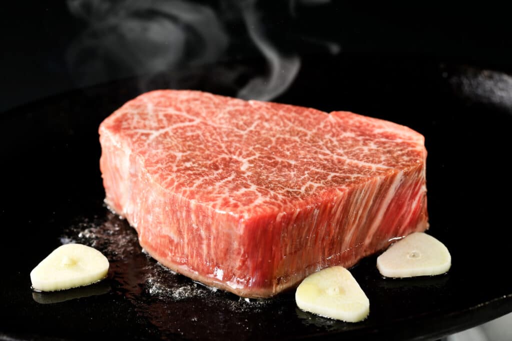 Premium wagyu beef steak with marbling cooking on hot plate