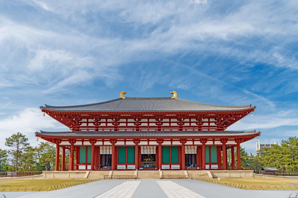 Yakushi-ji temple in Nara with red wooden structure under blue sky
