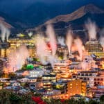 Steam rising above Beppu Onsen town at night