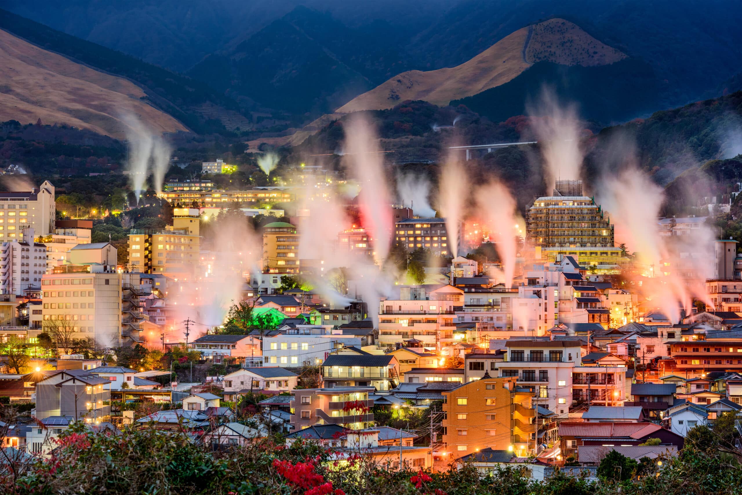 Steam rising above Beppu Onsen town at night
