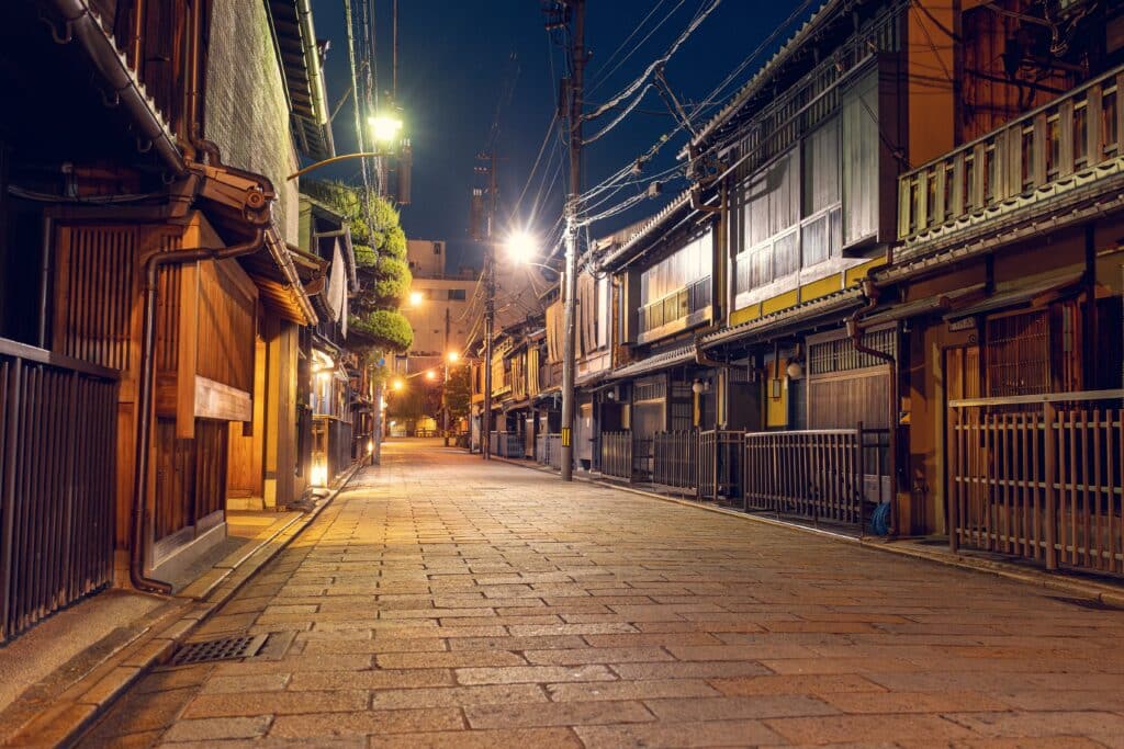 Traditional wooden houses lining a quiet street in Kyoto's historic Gion district at night