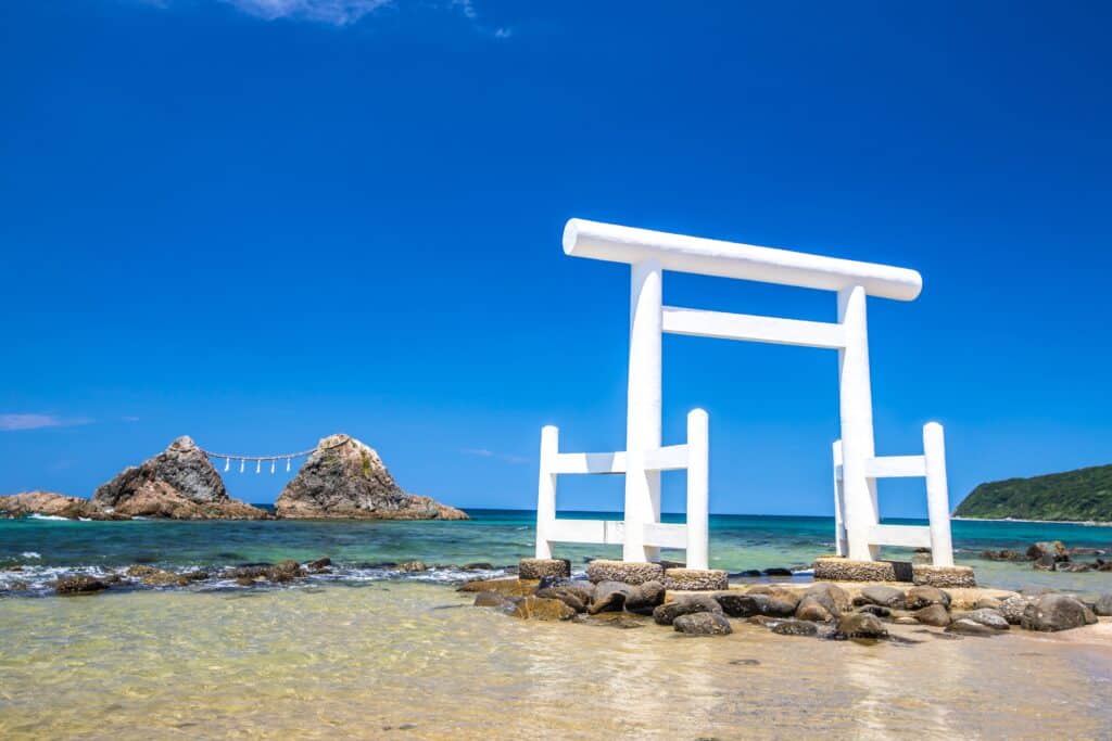 White torii gate and Meoto Iwa rocks at Futamigaura Beach in Itoshima