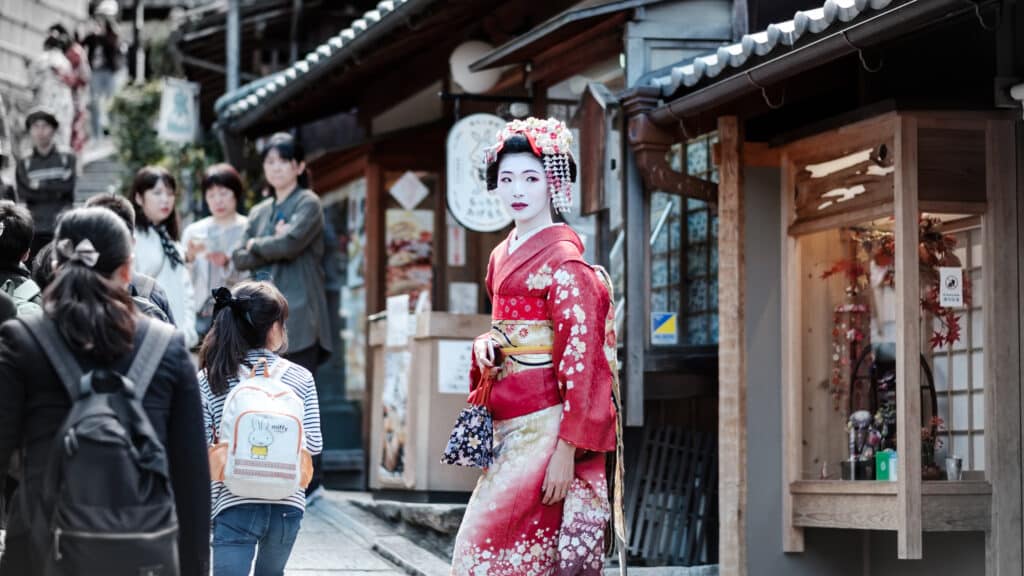 Woman in traditional kimono walking through a historic Kyoto street