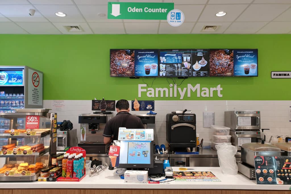 Interior of a FamilyMart convenience store showing food, drinks, and coffee counter
