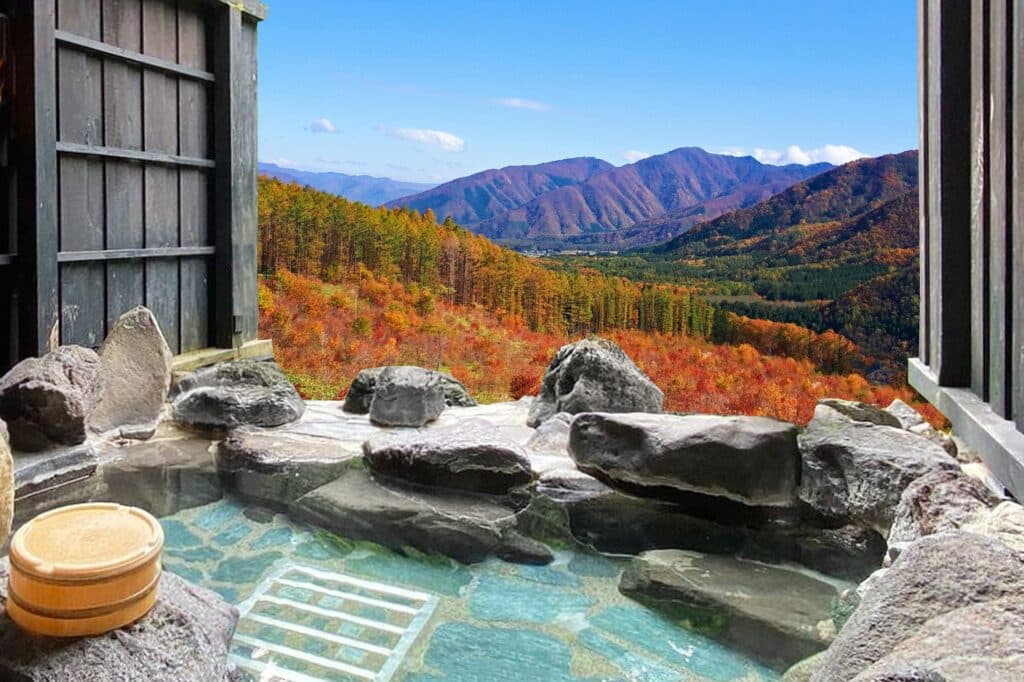 Outdoor onsen bath with autumn mountain scenery in Japan