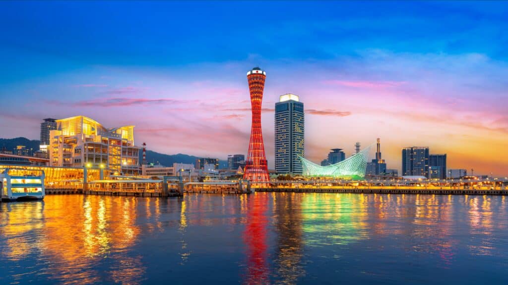 Kobe Harbor skyline at sunset with illuminated tower and waterfront reflections in Japan
