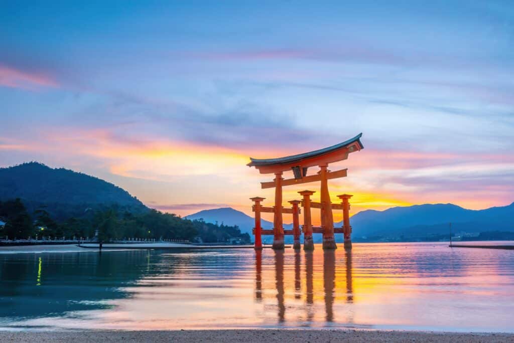 Floating torii gate of Miyajima at sunset with colorful reflections across Hiroshima Bay