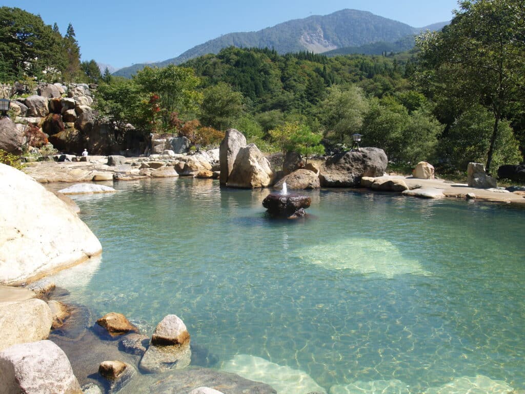 Large outdoor hot spring bath in Okuhida near Takayama surrounded by mountains