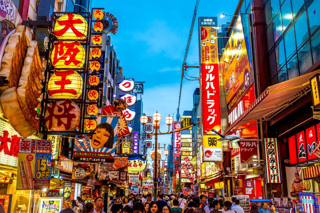 Dotonbori street in Osaka at night with neon signs, restaurants, and crowds