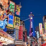 Shinsekai district in Osaka at night with Tsutenkaku Tower and bright neon signs