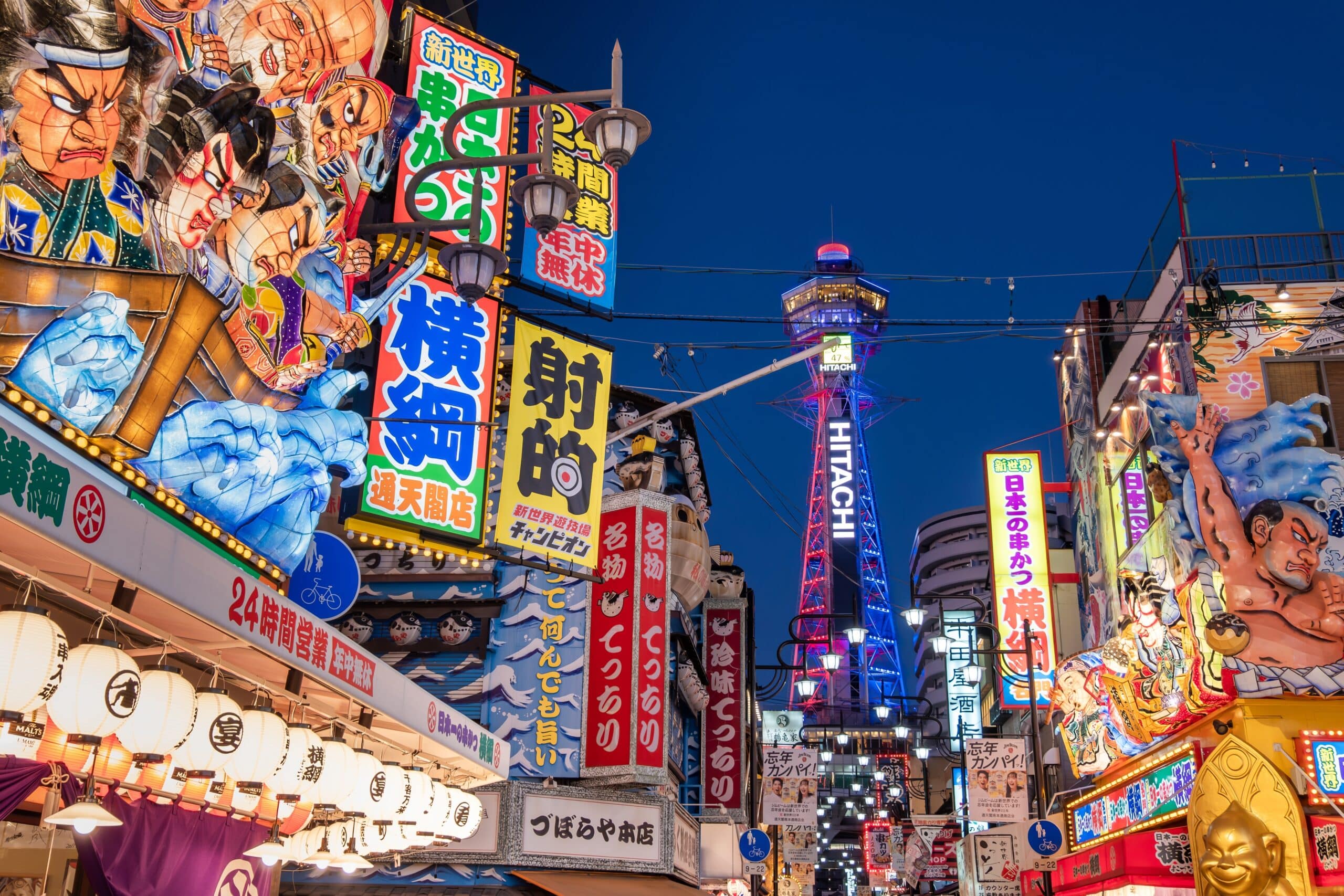 Shinsekai district in Osaka at night with Tsutenkaku Tower and bright neon signs