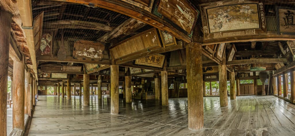 Interior of Senjokaku Hall showing wooden pillars and historic architecture on Miyajima
