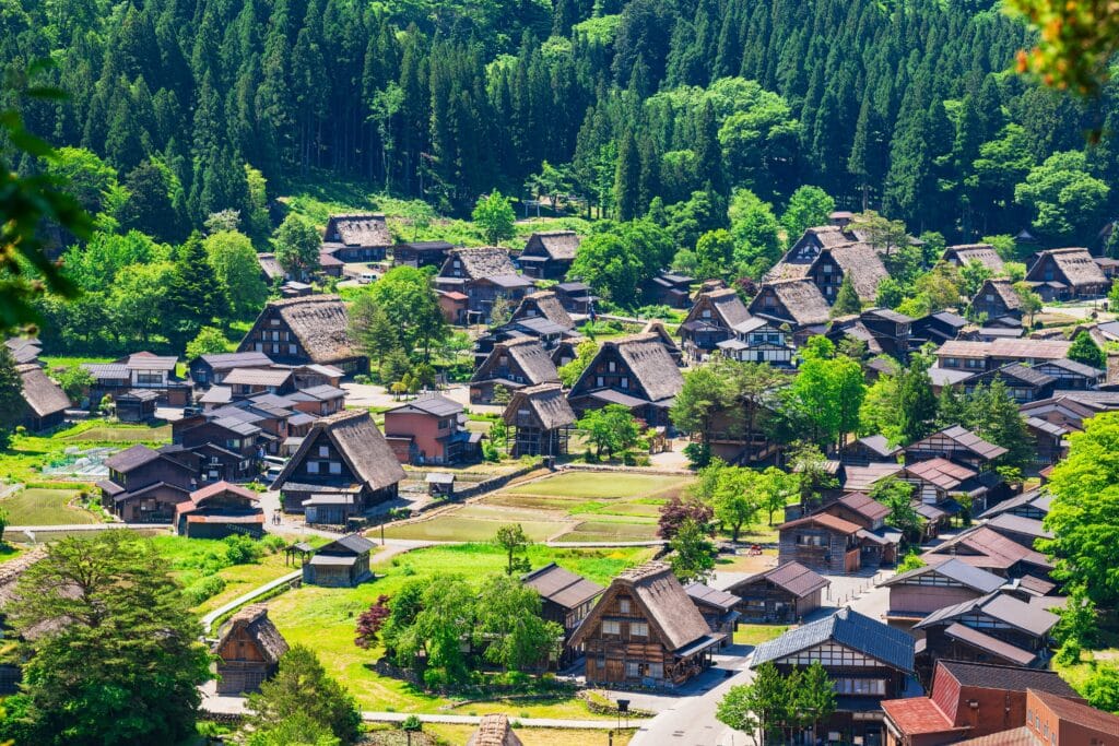 Traditional gassho-zukuri farmhouses in Shirakawa-go village surrounded by green mountains in Japan