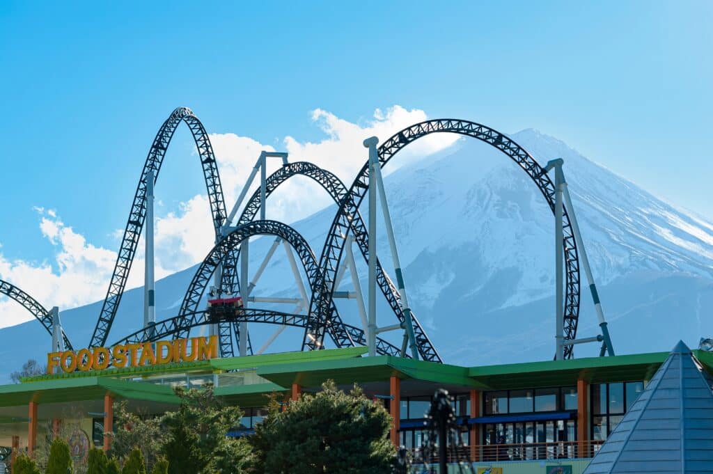 Roller coasters at Fuji-Q Highland with Mount Fuji rising behind them