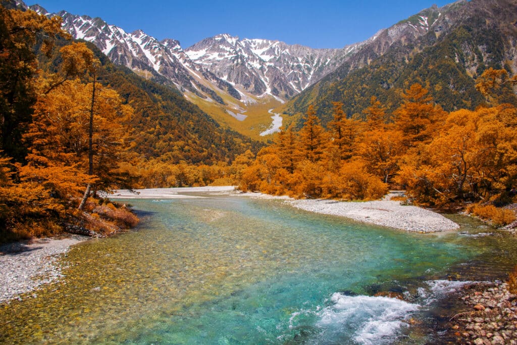 Kamikochi in autumn with colorful forests, turquoise river, and snow-capped peaks in the Japanese Alps