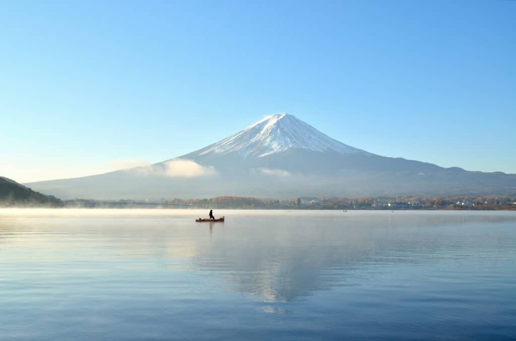 Calm waters of Lake Kawaguchi reflecting Mount Fuji on a clear morning