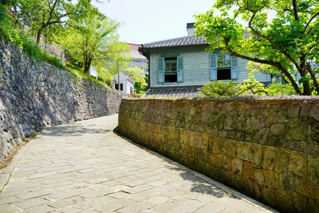 Stone-paved hillside street at Dutch Slope in Nagasaki lined with historic buildings and stone walls