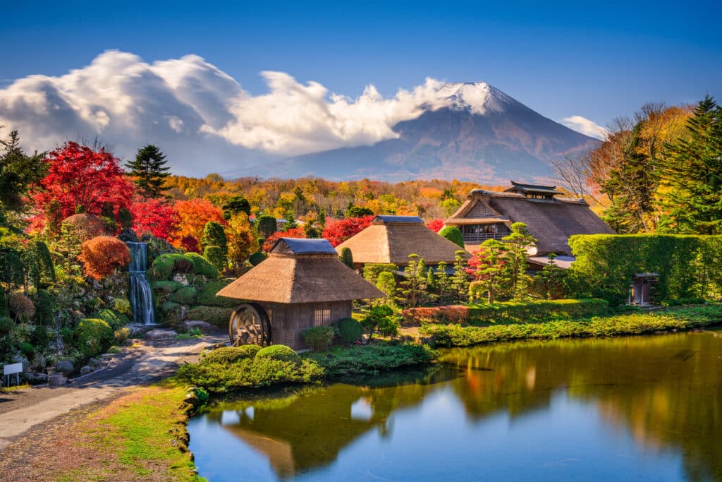 Traditional village buildings and gardens at Oshino Hakkai with Mount Fuji in autumn