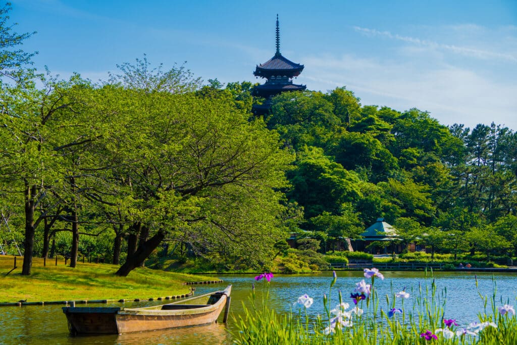 Traditional pagoda overlooking Sankeien Garden in Yokohama surrounded by lush greenery and a peaceful pond