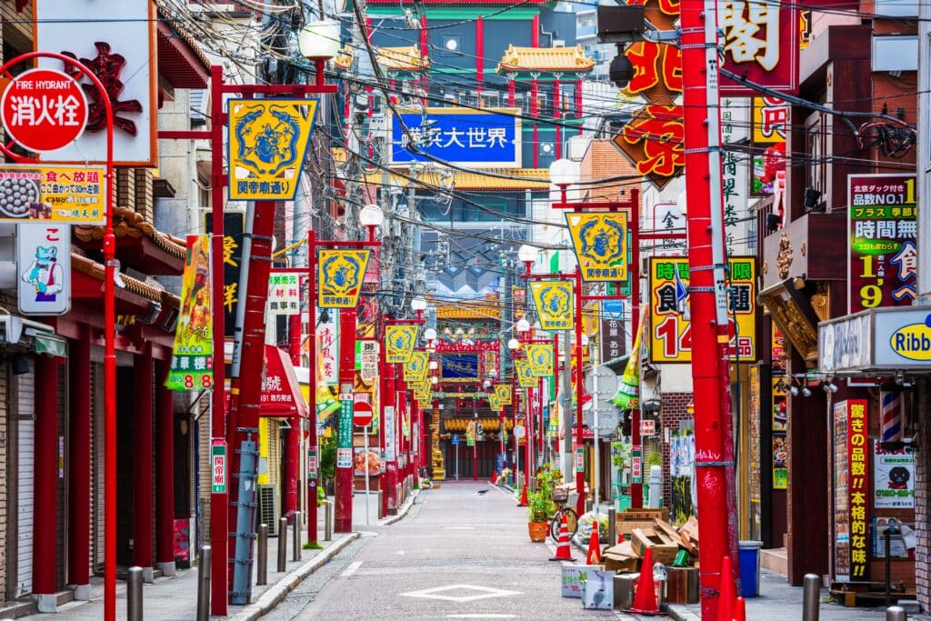 Colorful street lined with shops, restaurants, and signs in Yokohama Chinatown
