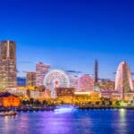 Illuminated Yokohama skyline at night with Landmark Tower, Ferris wheel, and waterfront reflections