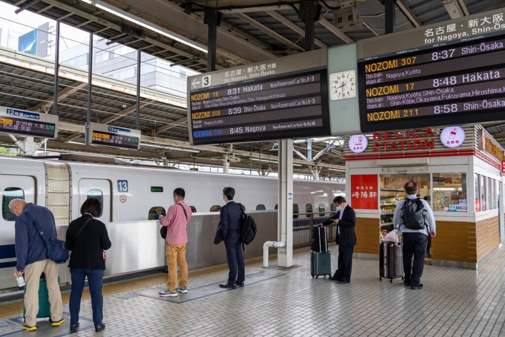 Passengers waiting beside a Shinkansen train at Shin-Yokohama Station in Japan