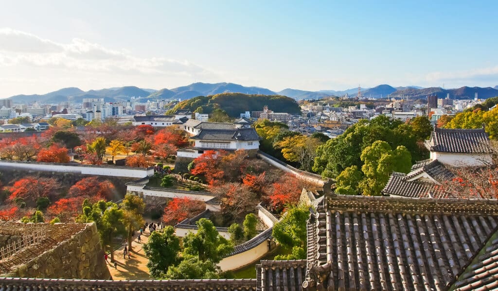 Panoramic autumn view from Himeji Castle overlooking the city and surrounding mountains in Japan