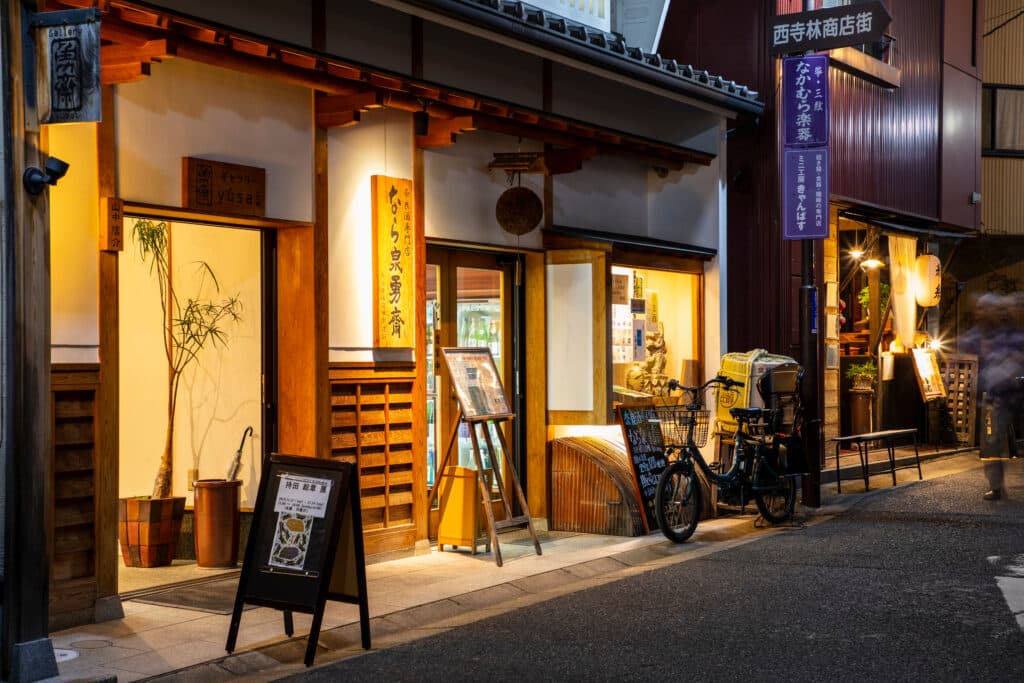Traditional wooden buildings and lantern-lit street in Naramachi historic district at night