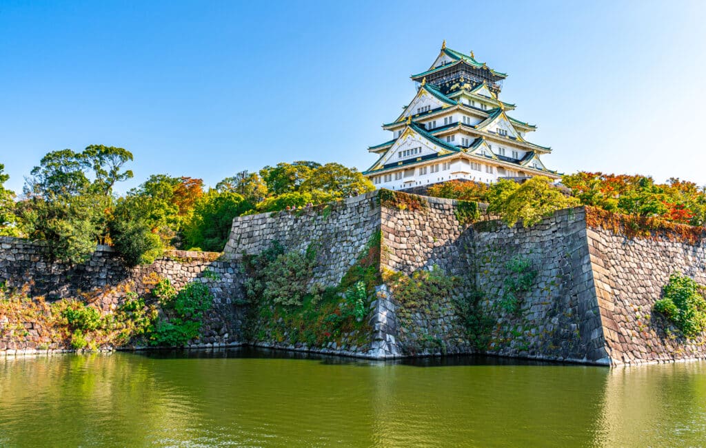 Osaka Castle surrounded by autumn colors and historic stone walls