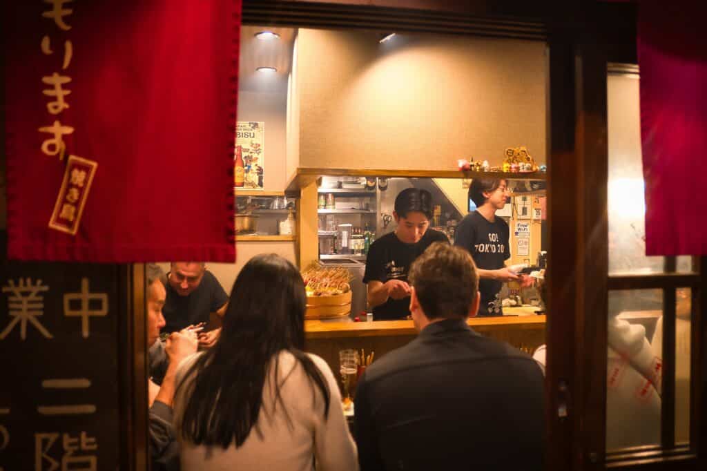 Visitors enjoying dinner at a traditional izakaya restaurant in Tokyo