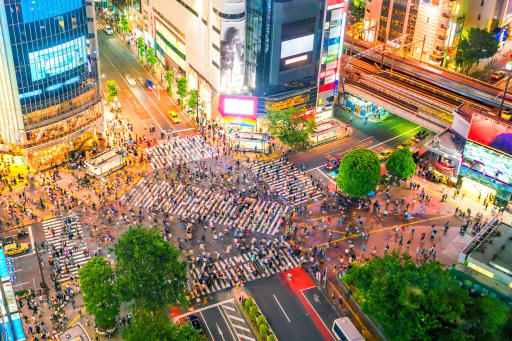 Crowds crossing Shibuya Crossing at night in Tokyo