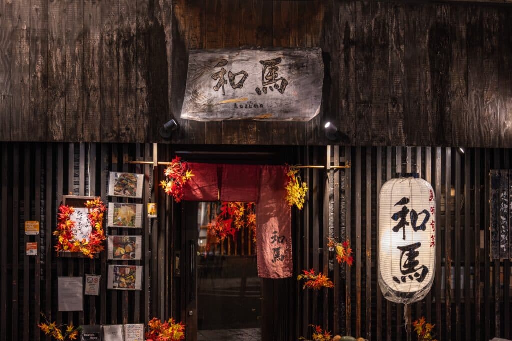 Traditional Japanese restaurant entrance in Kyoto with lantern and autumn decorations