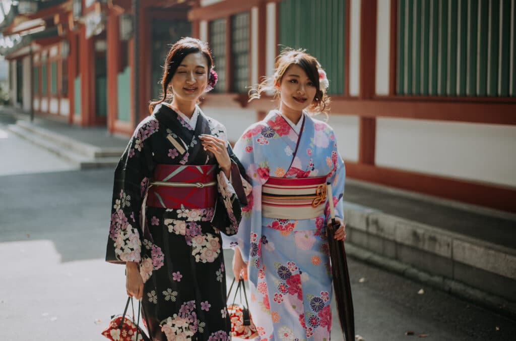Two women walking through Kyoto wearing colorful traditional kimonos