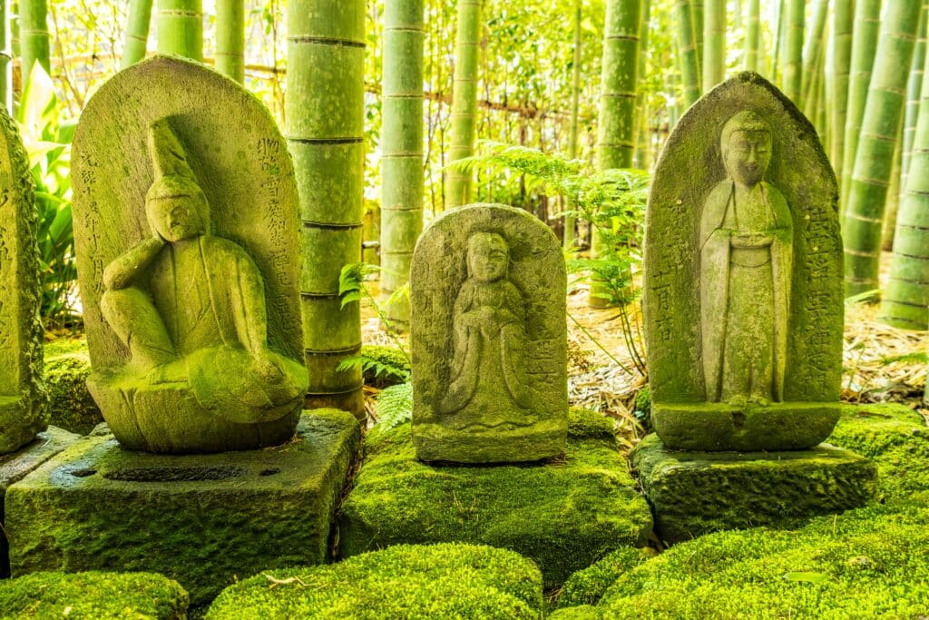 Stone Buddhist statues surrounded by bamboo at Hokokuji Temple in Kamakura