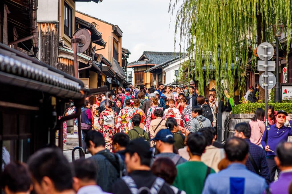 Crowded traditional street in Kyoto with visitors and people wearing kimono