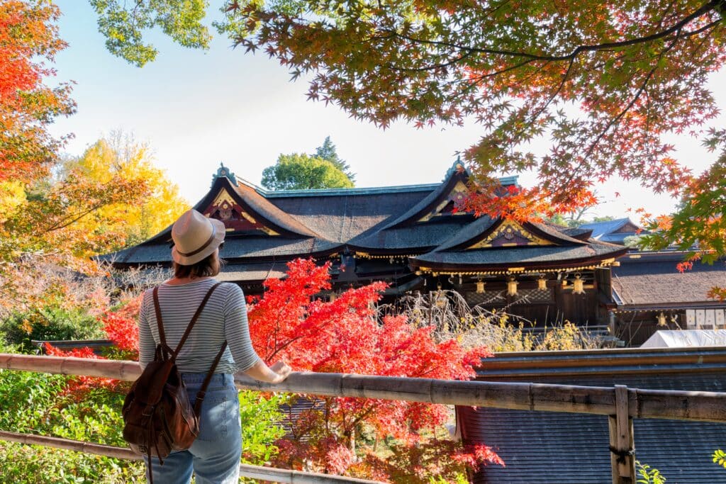 Traveler visiting a traditional temple in Kyoto during autumn