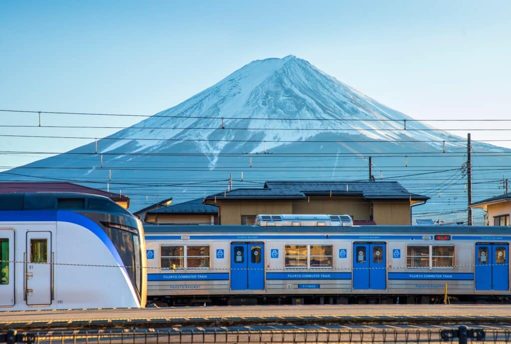 Train with snow-covered Mount Fuji in the background near Kawaguchiko, Japan