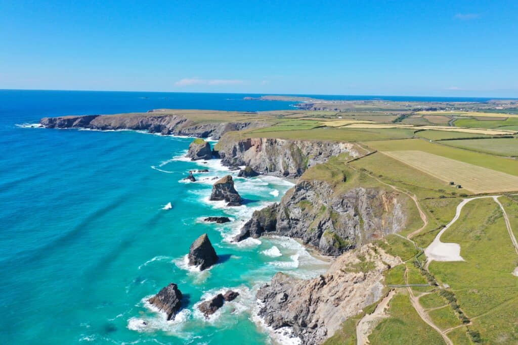 Aerial view of rugged cliffs and turquoise sea along the Cornwall coast